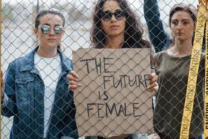 echt mensen. groep van feministisch Dames hebben protest voor hun rechten buitenshuis foto