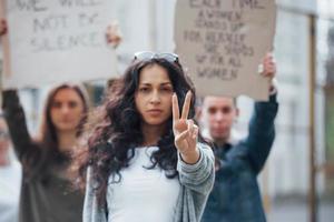 mooi brunette in voorkant. groep van feministisch Dames hebben protest voor hun rechten buitenshuis foto