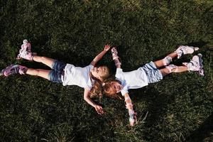 top visie. gevoel vrijheid. twee vrouw kinderen aan het liegen Aan de groen gras Bij zomertijd foto