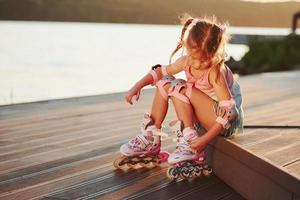 gelukkig schattig kind met haar rol schaatsen. ongelooflijk zonlicht foto