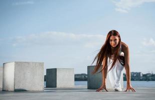 klaar voor de rennen. schot van sportief vrouw aan het doen geschiktheid opdrachten in de buurt de meer Bij dag foto