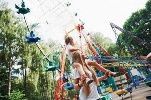 wandelen met dochter Aan de schouders. vrolijk weinig meisje haar moeder hebben een mooi zo tijd in de park samen in de buurt attracties foto