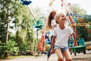 rennen en spelen. vrolijk weinig meisje haar moeder hebben een mooi zo tijd in de park samen in de buurt attracties foto