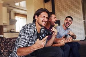 groep van vrienden hebben pret spelen troosten spel binnenshuis Bij leven kamer foto