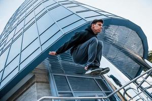 jong Mens aan het doen parkour in de stad Bij dag. opvatting van extreem sport- foto