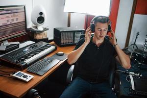 luisteren naar de muziek. geluid ingenieur in hoofdtelefoons werken en menging binnenshuis in de studio foto