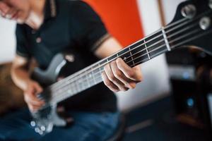 dichtbij omhoog visie van musicus Toneelstukken bas gitaar binnenshuis foto