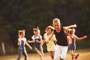 kinderen rennen in de veld- Bij zonnig dag. opvatting van gezond levensstijl foto