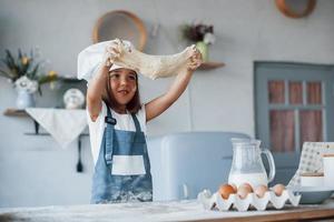 schattig kind in wit chef uniform voorbereidingen treffen voedsel Aan de keuken foto