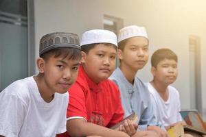 Aziatisch moslim of Islamitisch jongens zittend met moslim jongens in een rij naar bidden of naar Doen de religieus werkzaamheid, zacht en selectief focus. foto