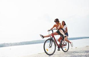 twee vrouw vrienden Aan de fiets hebben pret Bij strand in de buurt de meer foto