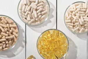 divers supplement pillen omega 3 en vitamines in Petri borden. gezondheidszorg steun, top visie, vlak leggen. foto