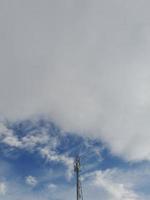 zender toren met een achtergrond van blauw lucht en bewolkt wolken foto
