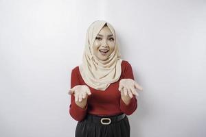jong Aziatisch vrouw vervelend een hijab presenteren een idee terwijl op zoek glimlachen Aan geïsoleerd wit achtergrond foto