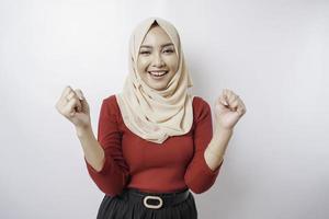 een jong Aziatisch moslim vrouw met een gelukkig geslaagd uitdrukking vervelend een hijab geïsoleerd door wit achtergrond foto