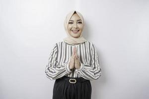 portret van een jong mooi moslim vrouw vervelend een hijab gebaren eid mubarak groet foto