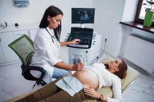 vrouw dokter doet echografie voor een zwanger vrouw in de ziekenhuis foto