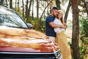 paar omarmen elk andere in de Woud in de buurt modern auto foto