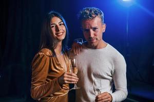 schattig paar staat samen Bij de partij met alcohol in handen foto