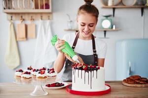 gieten room. vrouw staat binnenshuis in de keuken met eigengemaakt taart foto