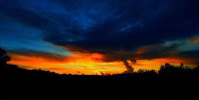 rood oranje zonsondergang met blauw getint wolken foto