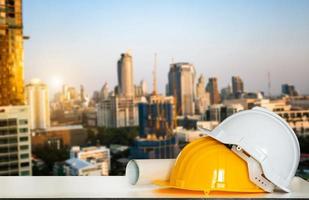 bouw huis en gebouw. reparatiewerkzaamheden. tekeningen voor gebouw en helm op witte tafel. foto