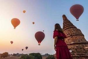 jong vrouw reiziger genieten van met ballonnen over- oude pagode Bij bagan, Myanmar Bij zonsopkomst foto