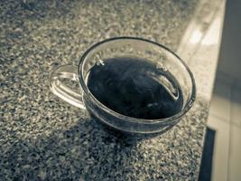 glas van koffie Aan de tafel in de keuken. foto