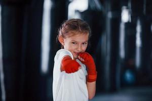 portret van jong weinig meisje in sportief slijtage dat is in de Sportschool hebben oefening dag. opvatting van boksen foto