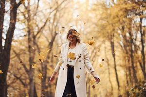 hebben pret met bladeren. portret van jong brunette dat is in herfst Woud Bij dag foto