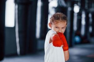 portret van jong weinig meisje in sportief slijtage dat is in de Sportschool hebben oefening dag. opvatting van boksen foto