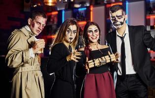 vrienden is Aan de thematisch halloween partij in eng bedenken en kostuums hebben pret en poseren voor de camera samen foto