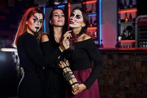 drie vrouw vrienden is Aan de thematisch halloween partij in eng bedenken en kostuums foto
