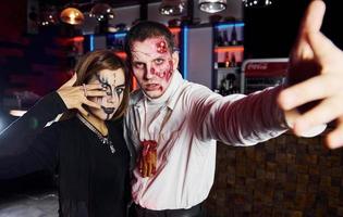 poseren voor de camera. vrienden is Aan de thematisch halloween partij in eng bedenken en kostuums foto