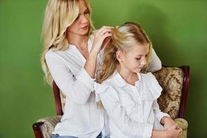 moeder met haar dochter samen in de studio met groen achtergrond foto