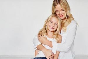 moeder met haar dochter hebben pret samen in de studio met wit achtergrond foto