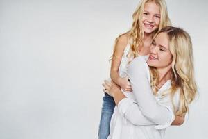 moeder met haar dochter hebben pret samen in de studio met wit achtergrond foto