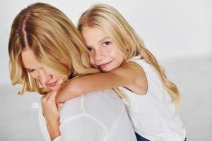 moeder met haar dochter hebben pret samen in de studio met wit achtergrond foto