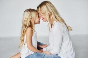 moeder met haar dochter samen in de studio met wit achtergrond foto