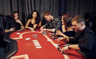 top visie van elegant jong mensen dat spelen poker in casino foto