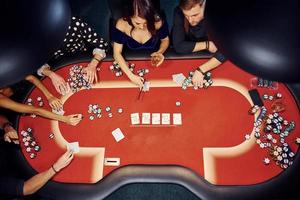 top visie van elegant jong mensen dat spelen poker in casino foto
