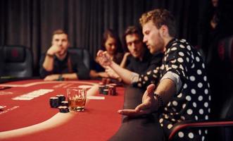 kant visie van groep van elegant jong mensen dat spelen poker in casino samen foto