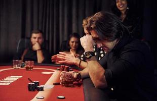 groep van elegant jong mensen dat spelen poker in casino samen foto