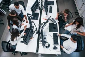 groep van jong bedrijf mensen dat werken door computers in de modern kantoor foto