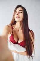 vrouw in ondergoed nemen selfie in de studio tegen wit achtergrond foto