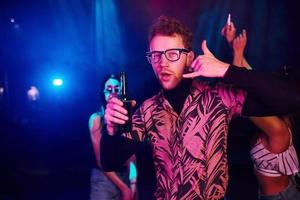 vent in bril drankjes bier. jong mensen is hebben pret in nacht club met kleurrijk laser lichten foto