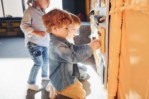 kinderen hebben pret in speelkamer in de buurt de muur. kleuterschool leerzaam spellen foto