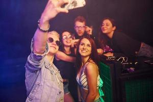 jong mensen maken selfie in nacht club met kleurrijk laser lichten foto