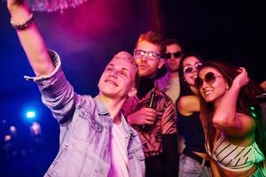 jong mensen maken selfie in nacht club met kleurrijk laser lichten foto