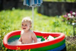 weinig meisje zwemmen in zwembad foto